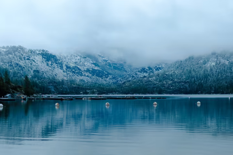 Snow-covered Sierra Nevada mountains reflected in a calm alpine lake